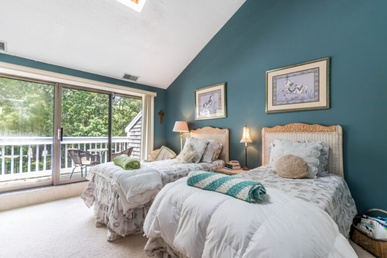 a bedtoom with two single beds and glass doors to a balcony