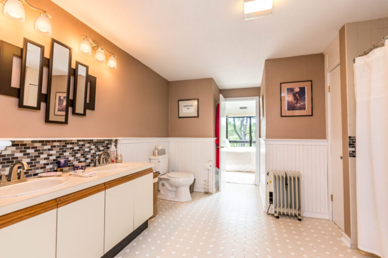 Spacious bathroom with a shower, toilet, vanity, and a view through the window.