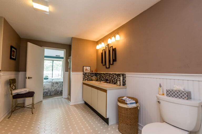 Spacious bathroom with a shower, toilet, vanity, and a view through the window.