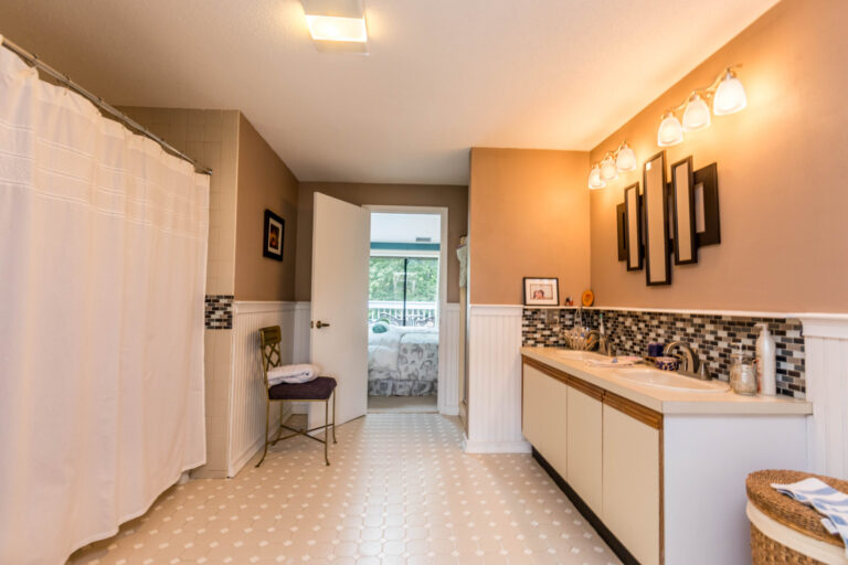 Spacious bathroom with a shower, toilet, vanity, and a view through the window.