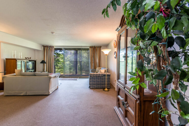 a family room with a simple couch, a vintage-style TV, and a small wooden cabinet