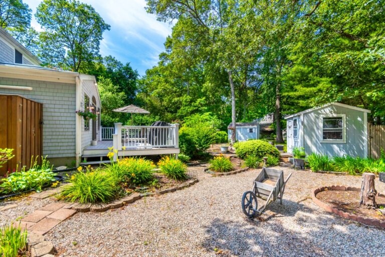 a backyard with full of plants and a deck