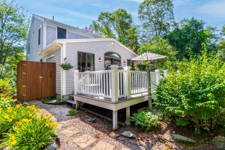 a backyard with full of plants and a deck