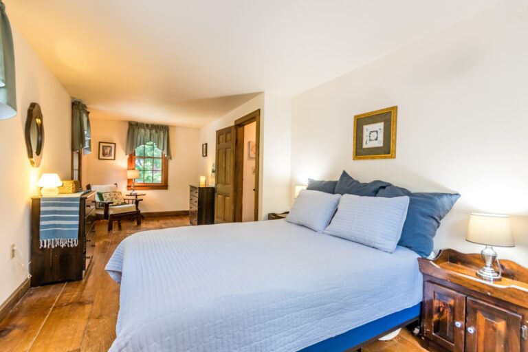 a master bedroom with bed, cabinet and side tables