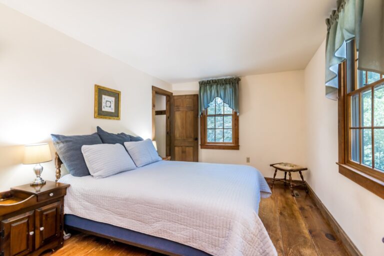 a master bedroom with bed, cabinet and side tables