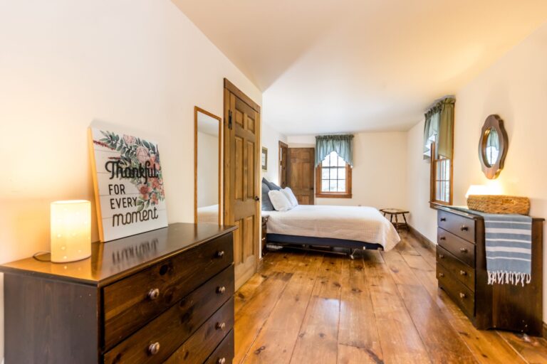 a master bedroom with bed, cabinet and side tables
