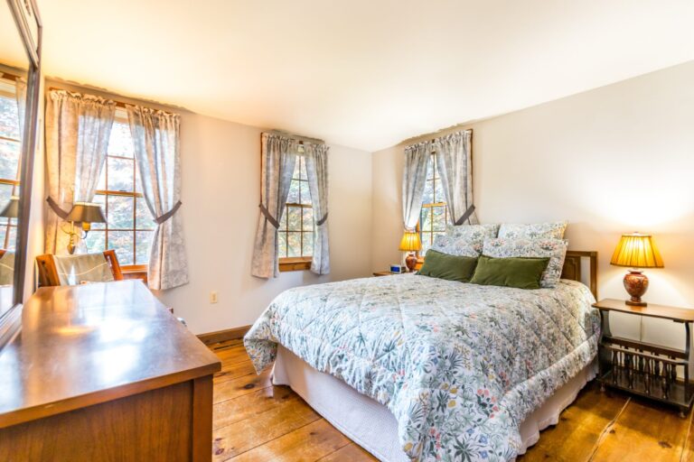 a bedroom with bed, cabinet and side tables