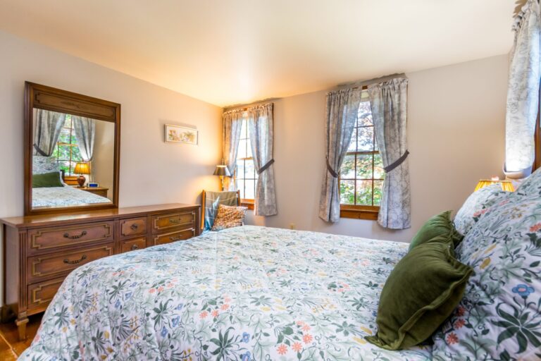 a bedroom with bed, cabinet and side tables
