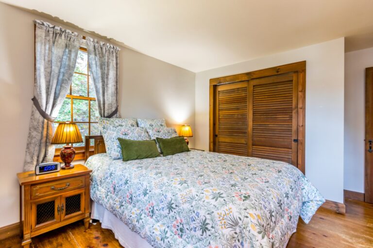 a bedroom with bed, cabinet and side tables