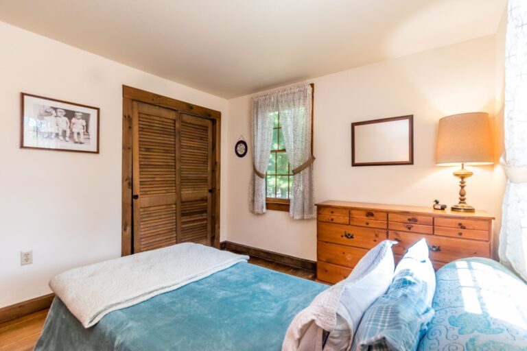 a bedroom with bed, cabinet and side tables