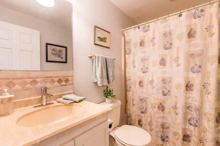 a bathroom with mirrors, tiolet, lavatory, and curtain shower