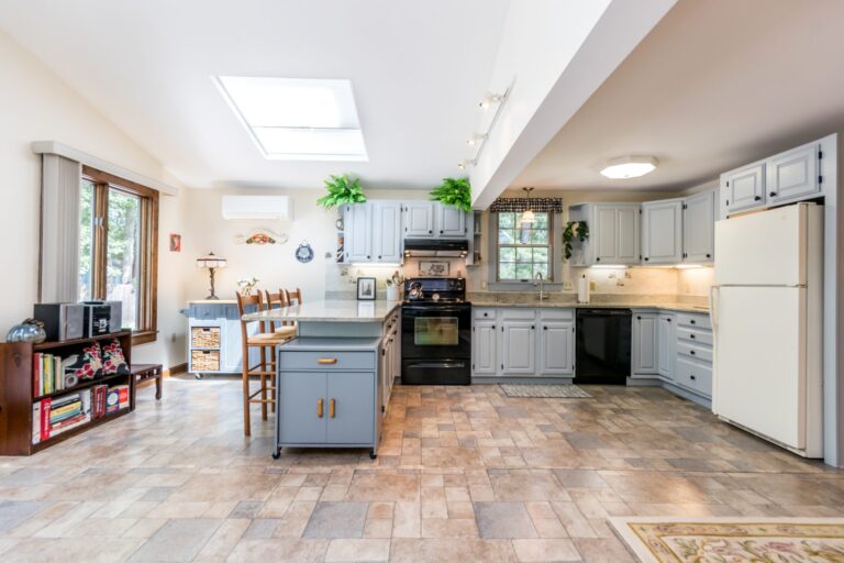 a kitchen with breakfast nook, white cabinets, and stainless steel appliance