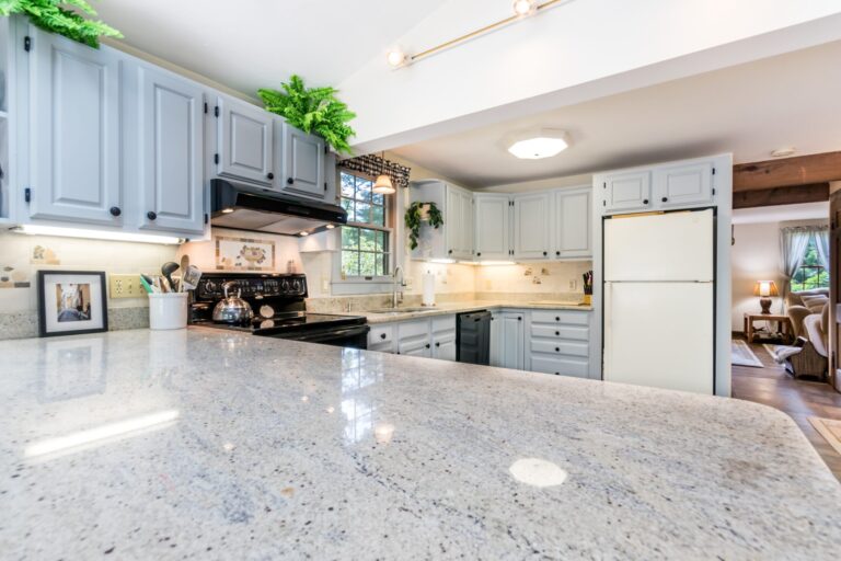 a kitchen with breakfast nook, white cabinets, and stainless steel appliance