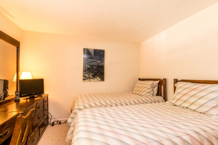 a bedroom with 2 beds and wooden furnitures