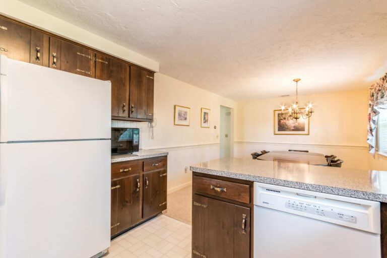 a kitchen with a countertop, stainless steel appliances and wooden cabinets