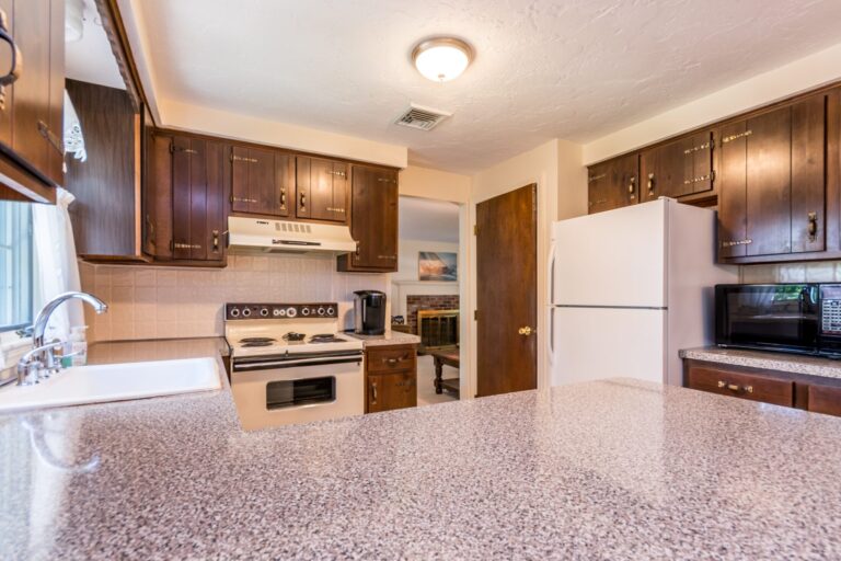 a kitchen with a countertop, stainless steel appliances and wooden cabinets