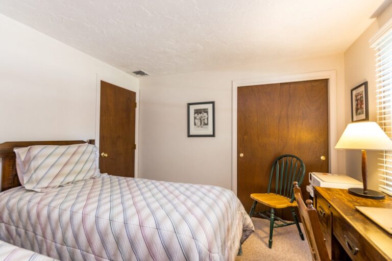 a bedroom with 2 beds and wooden furnitures