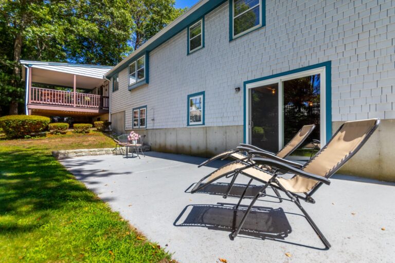 a backyard of a property with foldable chairs and glass doors