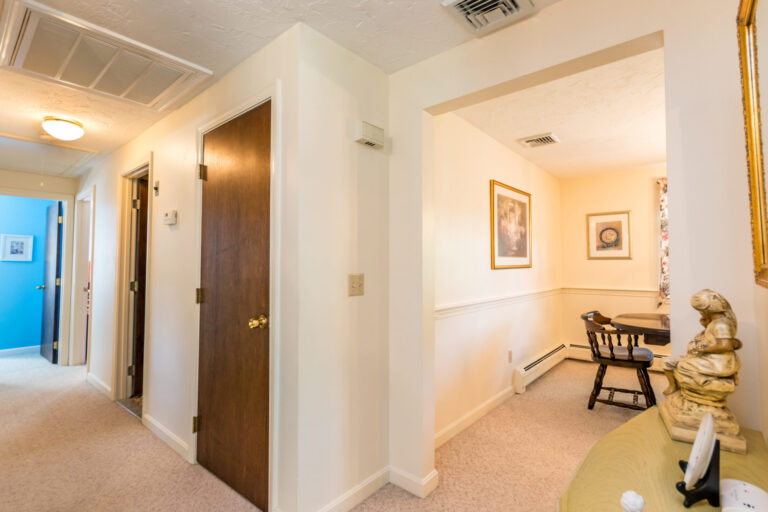 Foyer with multiple doorways leading to different rooms and a wooden entry table