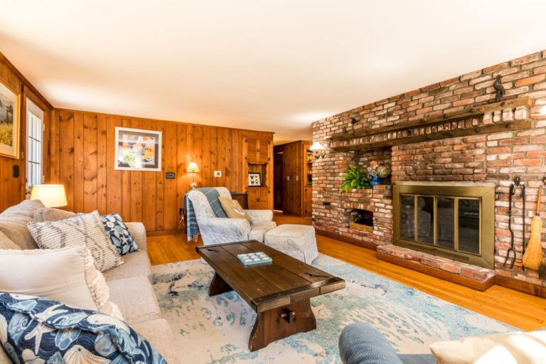 a living room with couch, fireplace, table and TV