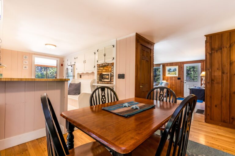 a wooden dining table with chairs overlooking the living room and kitchen