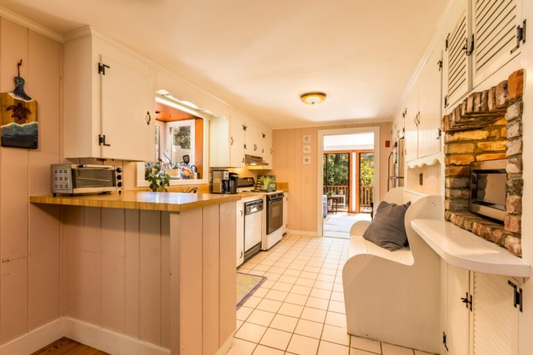 a kitchen with white cabinets and appliances
