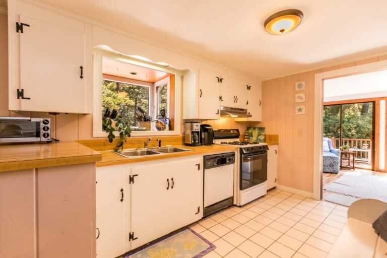 a kitchen with white cabinets and appliances