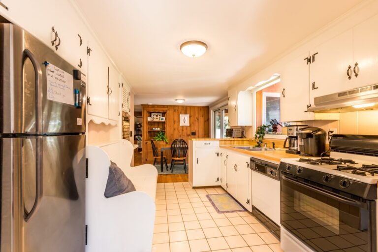 a kitchen with white cabinets and appliances