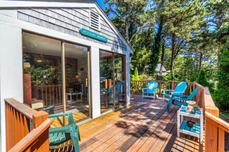 a wooden deck with blue wooden chairs