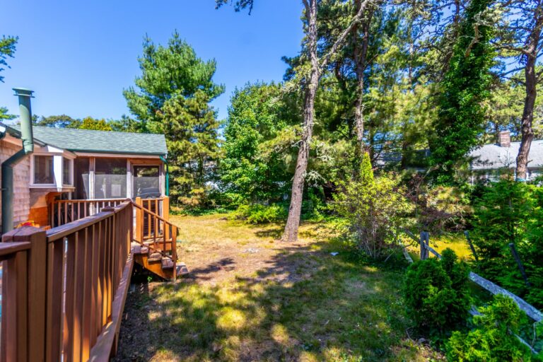 a spacious yard beside a deck