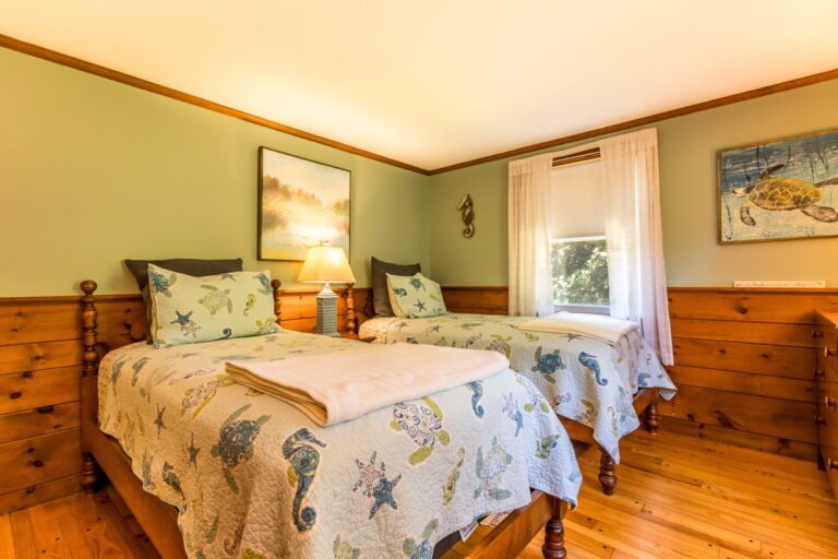 a bedroom with 2 beds and has ocean animal sheets