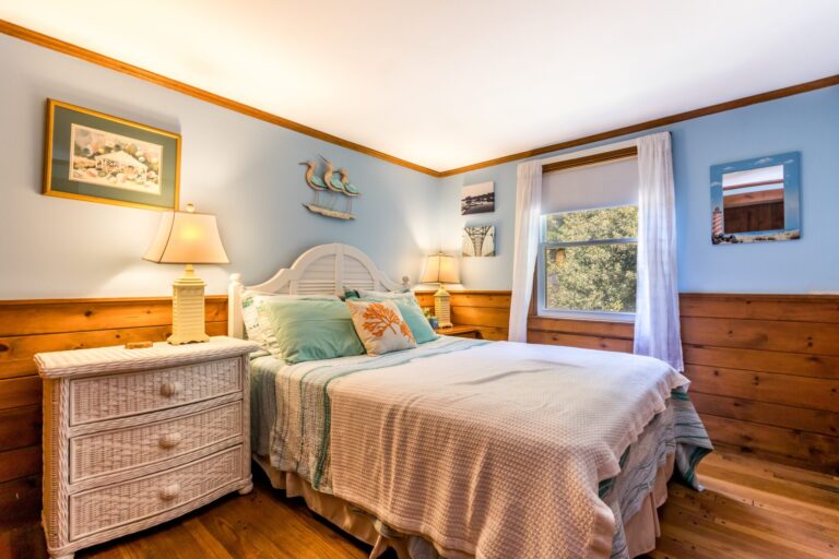 a bedroom with 1 big bed with side tables, white drawer and lamp shades