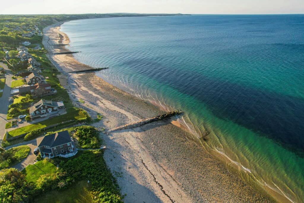 a beach with houses and trees near the shore