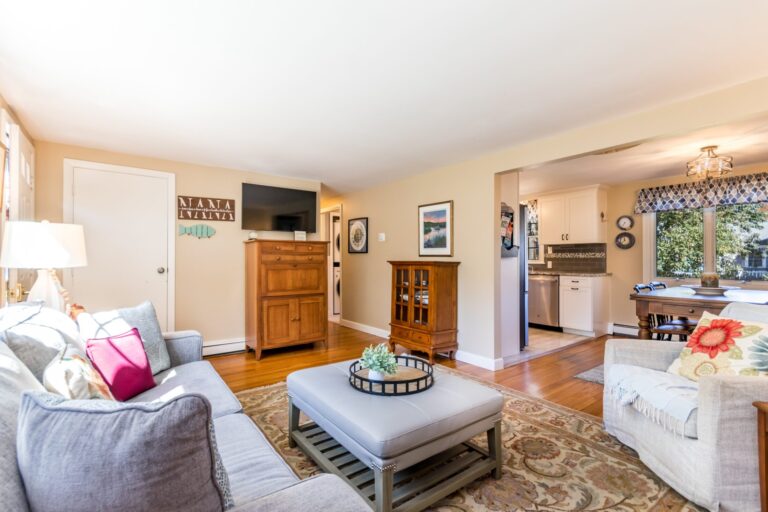 a living room with fireplace, wooden furnitures and lots of natural light