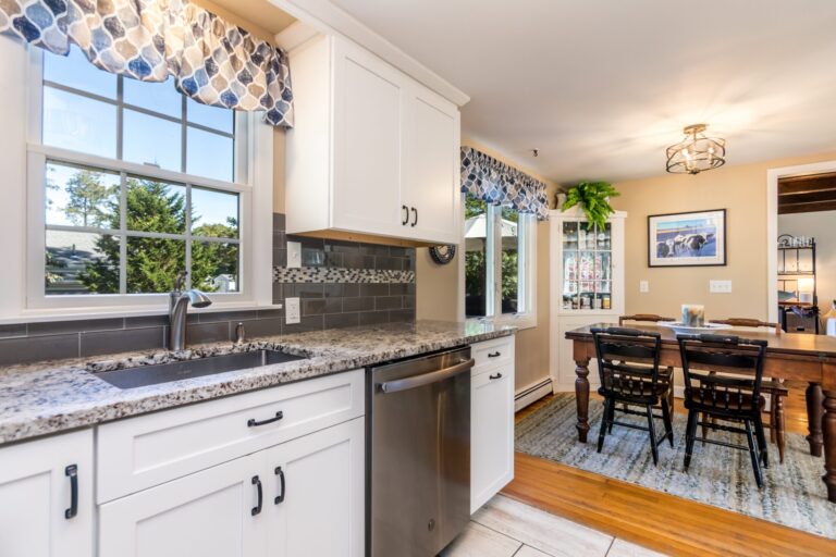 a kitchen with granite countertops, stainless steel appliances and white cabinets