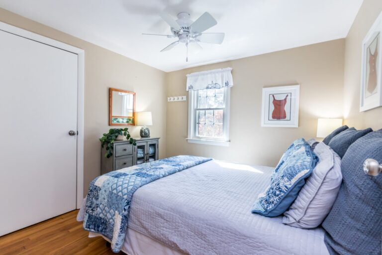 a room with a bed with blue blanket and beddings