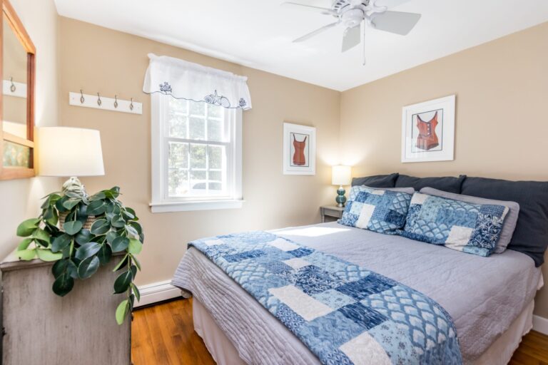 a room with a bed with blue blanket and beddings