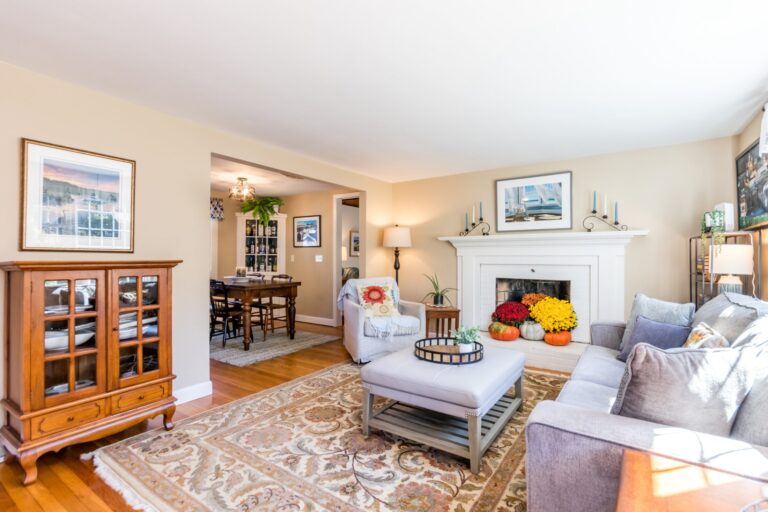 a living room with fireplace, wooden furnitures and lots of natural light
