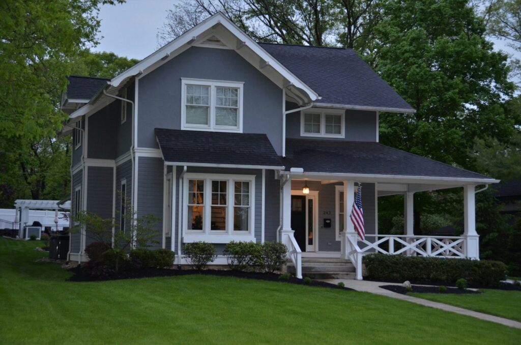 white and gray wooden house near green grass field during daytime
