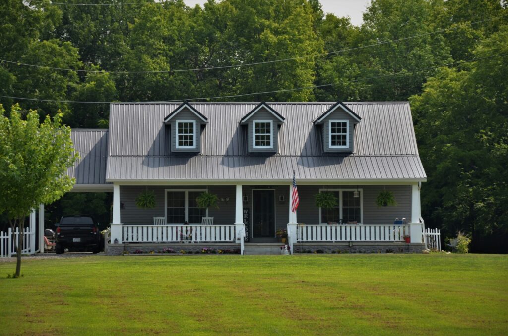 white and black wooden house near green trees during daytime