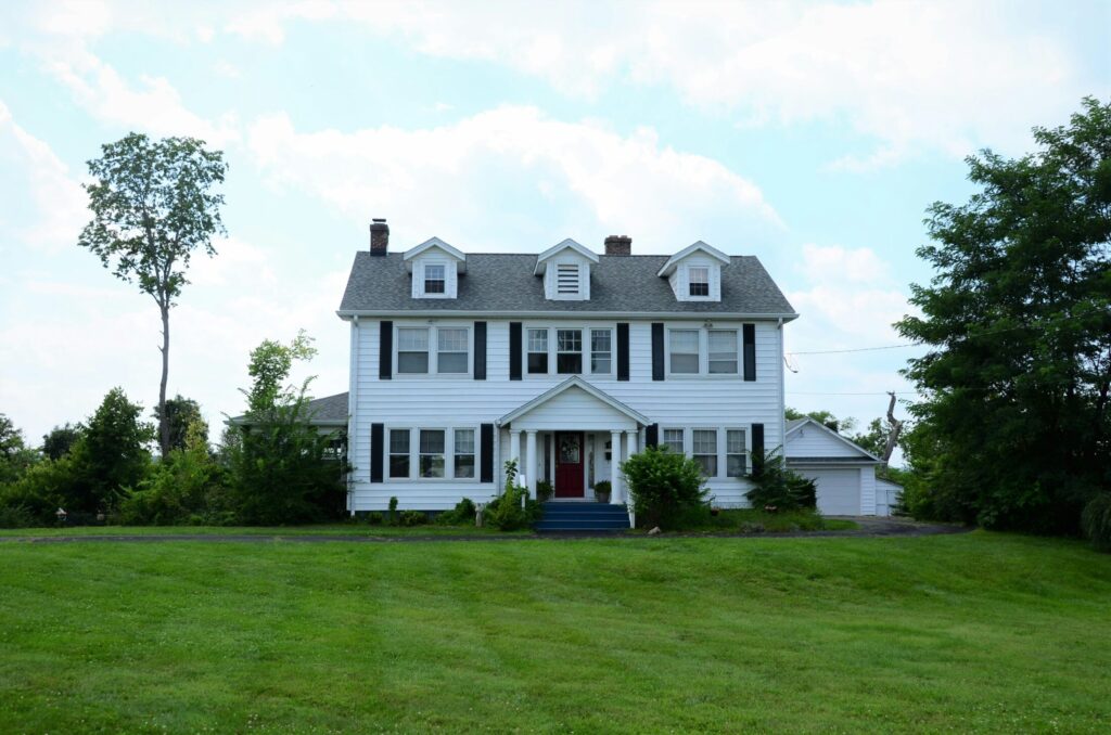 a large white house sitting on top of lush green field
