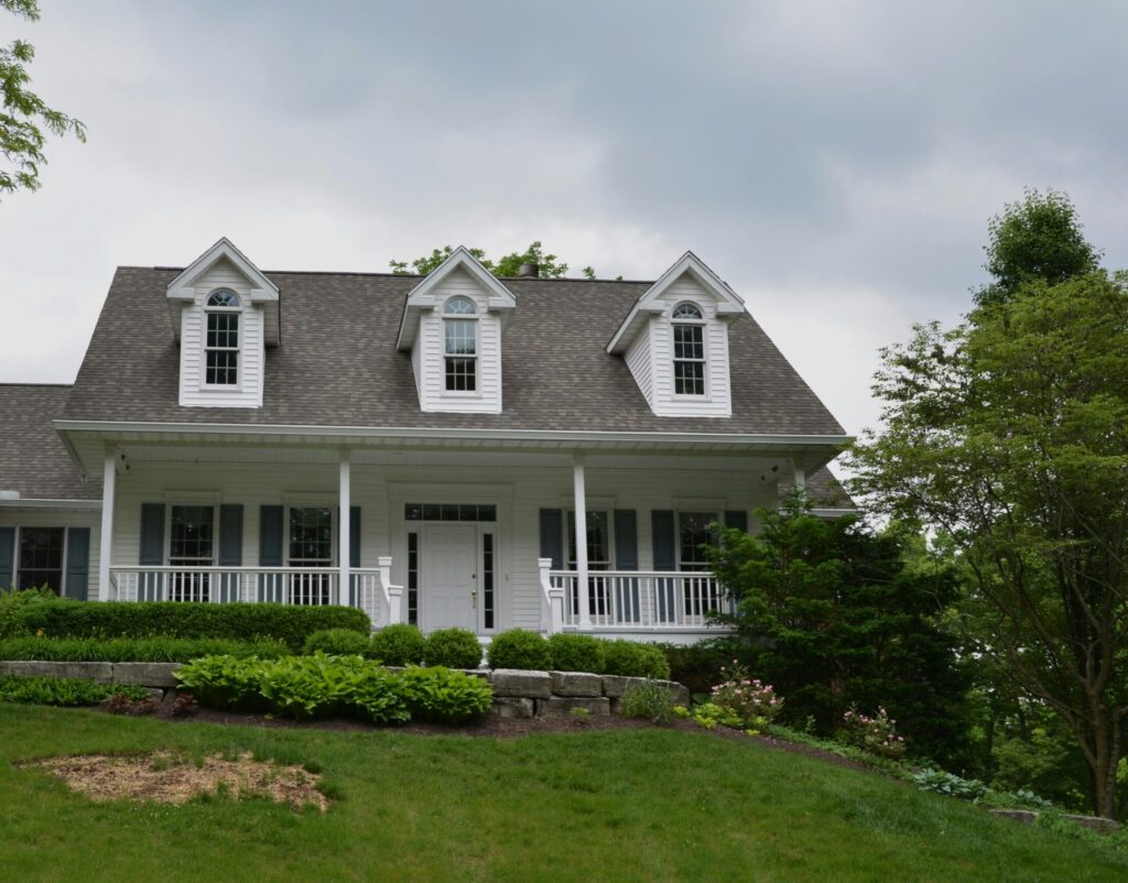 a white house with gray roof and white shutters