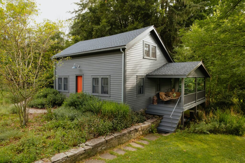 a small gray house with a red door