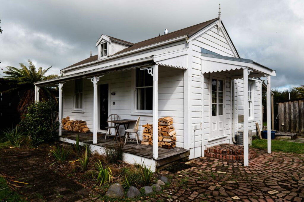 a small white house with a covered porch.