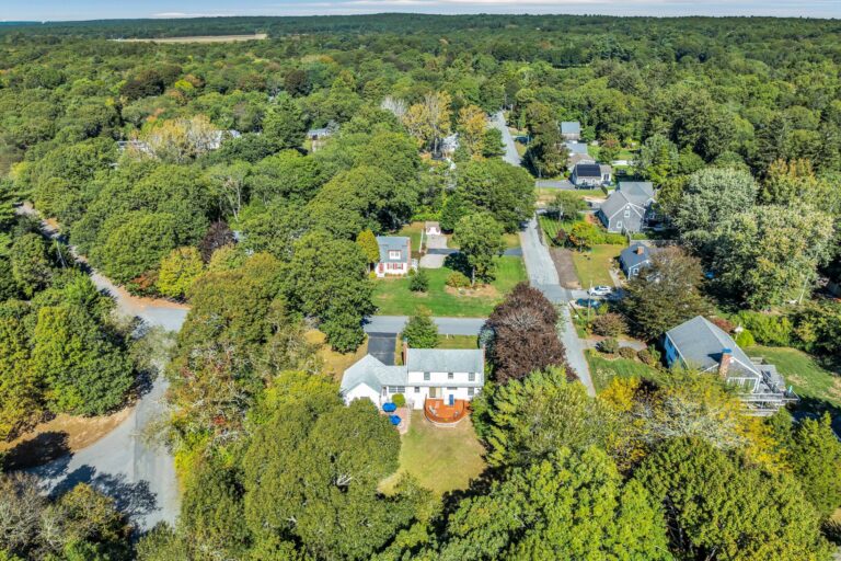 a aerial view of a residential property surrounded by dense forest