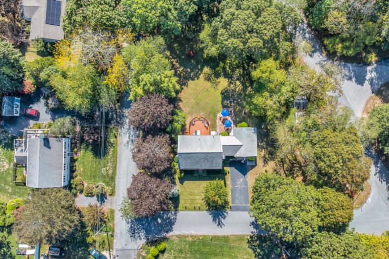 a aerial view of a residential property surrounded by dense forest
