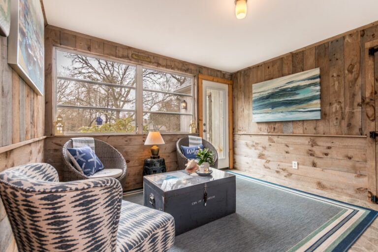 a rustic sunroom furnished with coastal-themed decor