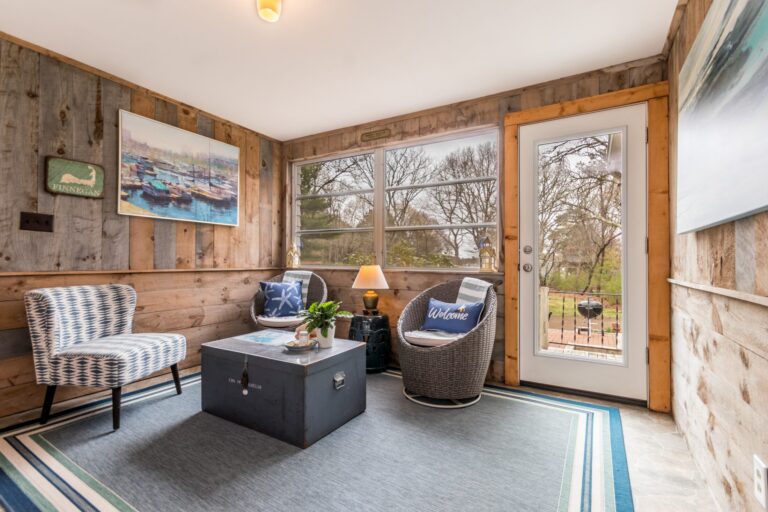 a rustic sunroom furnished with coastal-themed decor