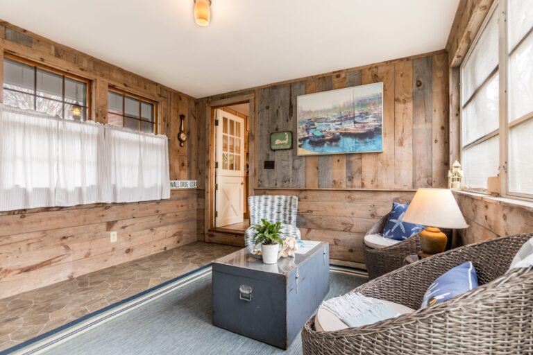 a rustic sunroom furnished with coastal-themed decor