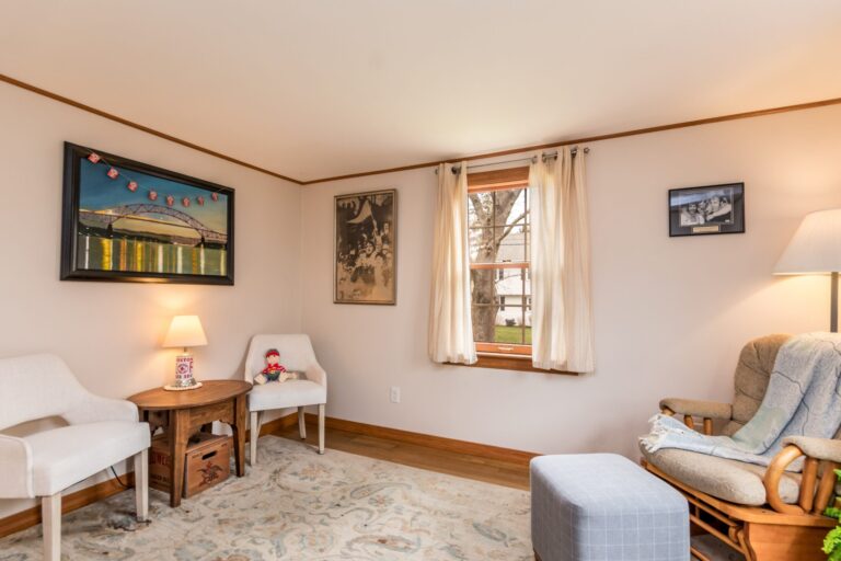 a den with chairs, television and small windows
